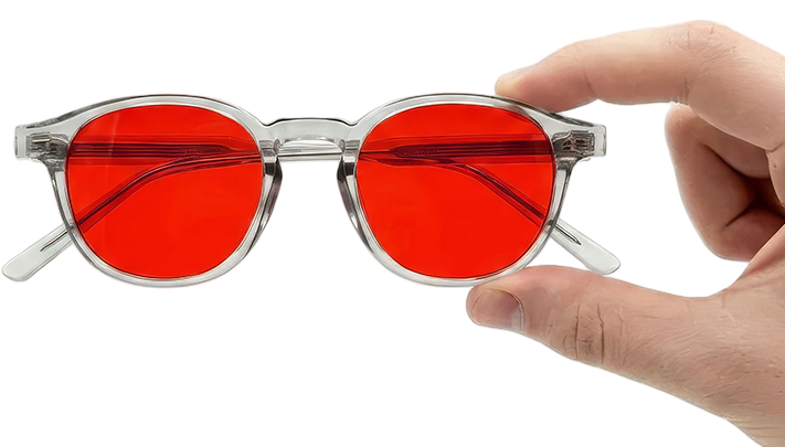 Freddie Bedtime Glasses with red lenses and clear acetate frame held in hand