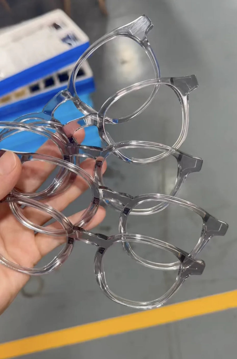 Three pairs of prototype Freddie acetate frames held in a hand